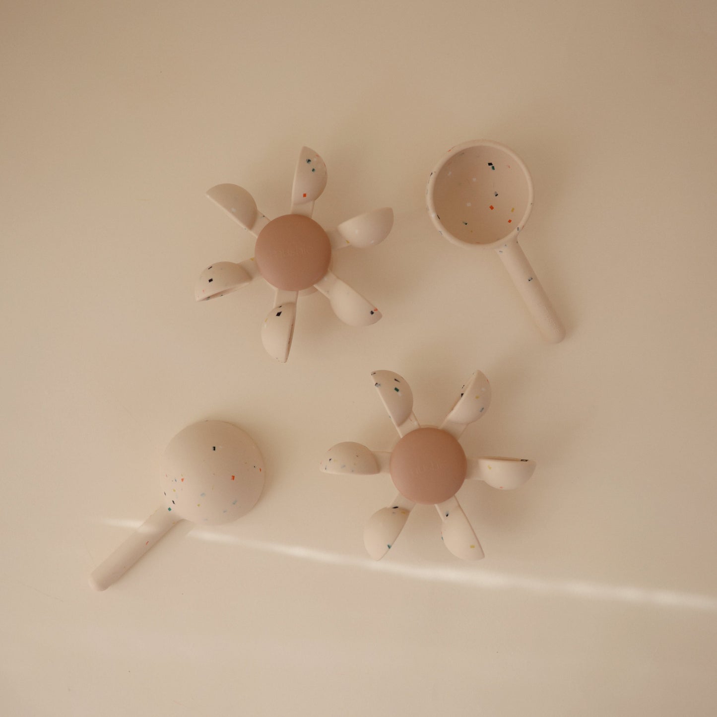 Four bath toys set against a beige backdrop.
