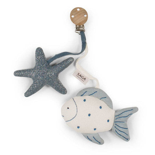 A plush toy featuring a stylized fish with blue sea stars, attached to a clip with a wooden accent, against a white background.