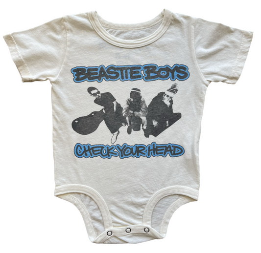 A white short-sleeved onesie with 'Beastie Boys Check Your Head' text and graphics printed on the front.
