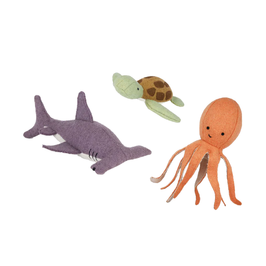 Three plush toy animals representing marine life - an octopus, a turtle, and a shark, all made from a soft wool blend with embroidered features.