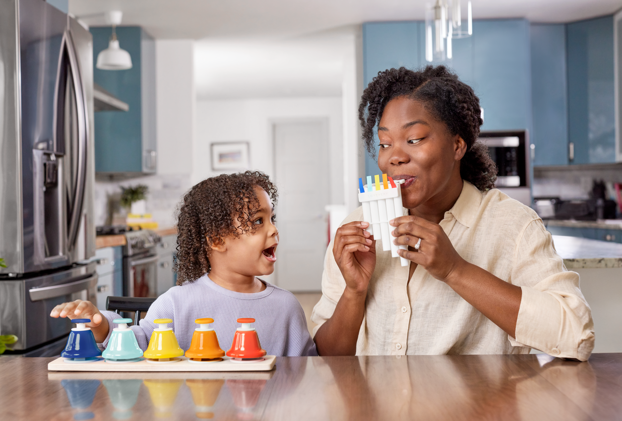 Woman and child in a kitchen with colorful bottles on a counter