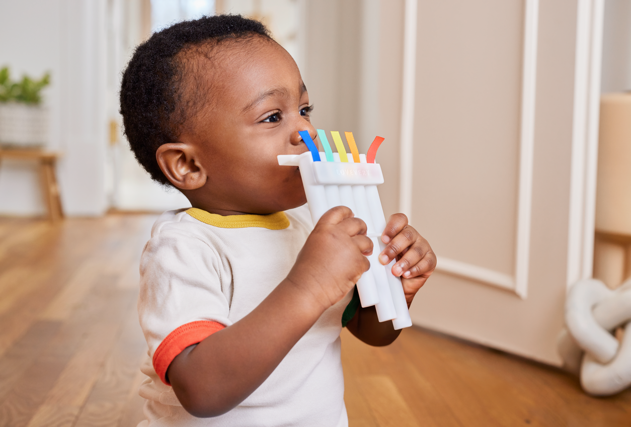 Child holding a colorful toy indoors