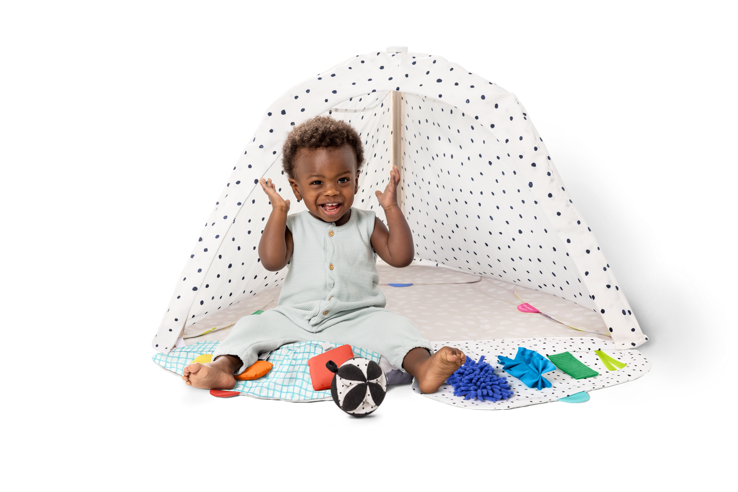 Child playing with toys on a white floor with a white canopy in the background
