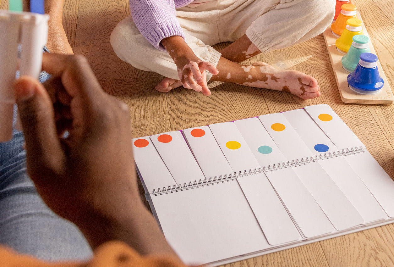 Child playing with colorful educational toys on a wooden floor