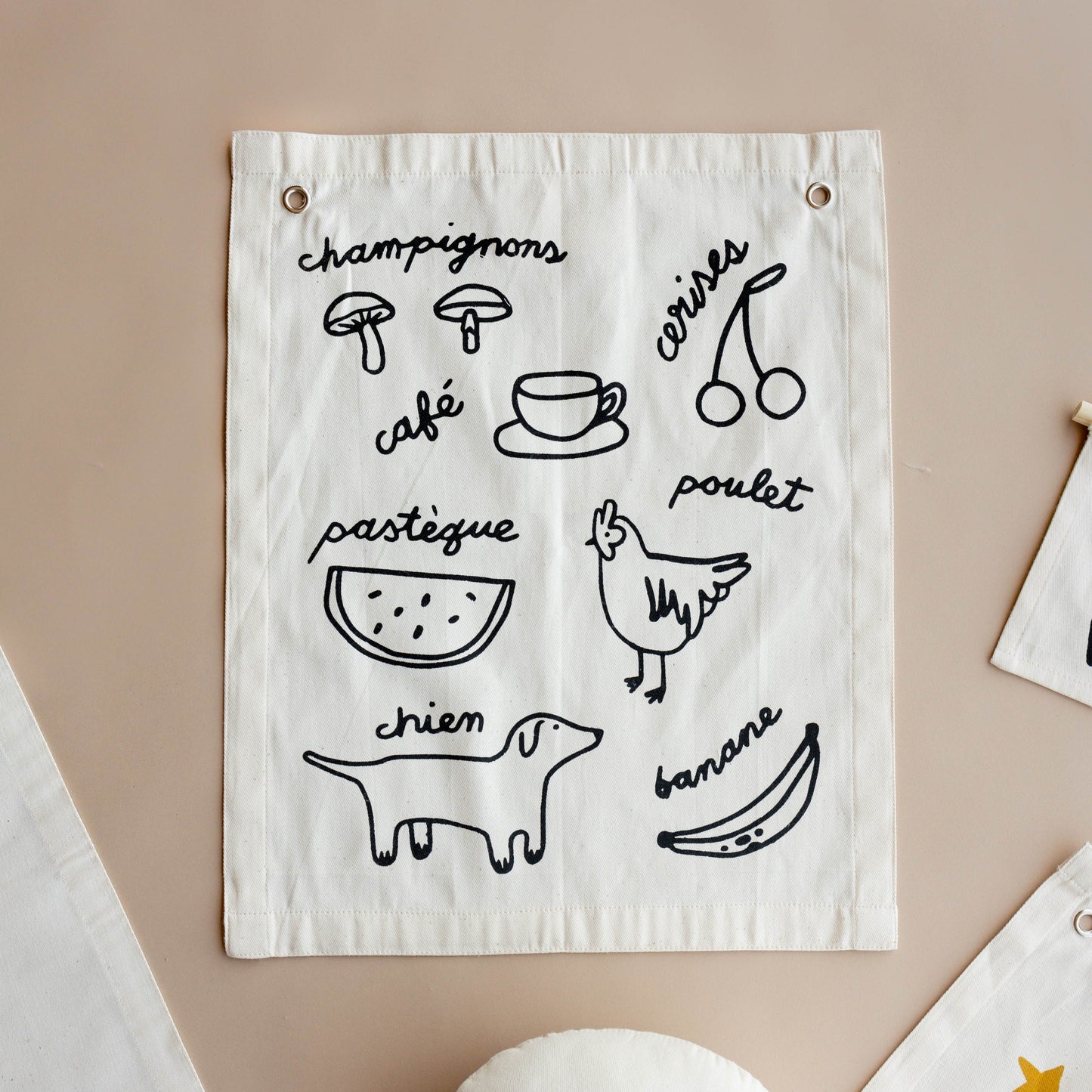White fabric wall hanging with black line drawings and text on a beige background