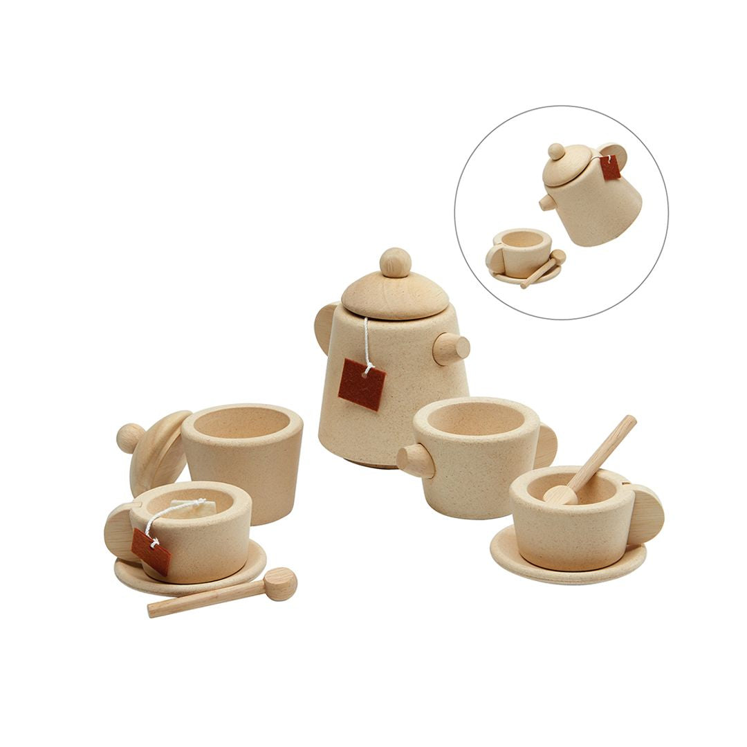 Set of wooden tea pots and cups with a teacup and saucer on a white background