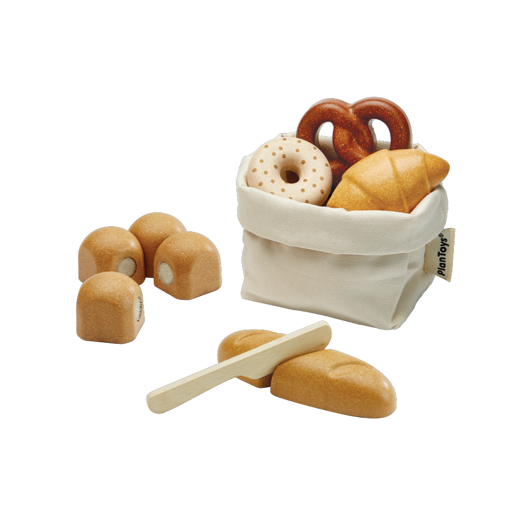 Set of wooden toy bread and pastries with a white bag on a white background