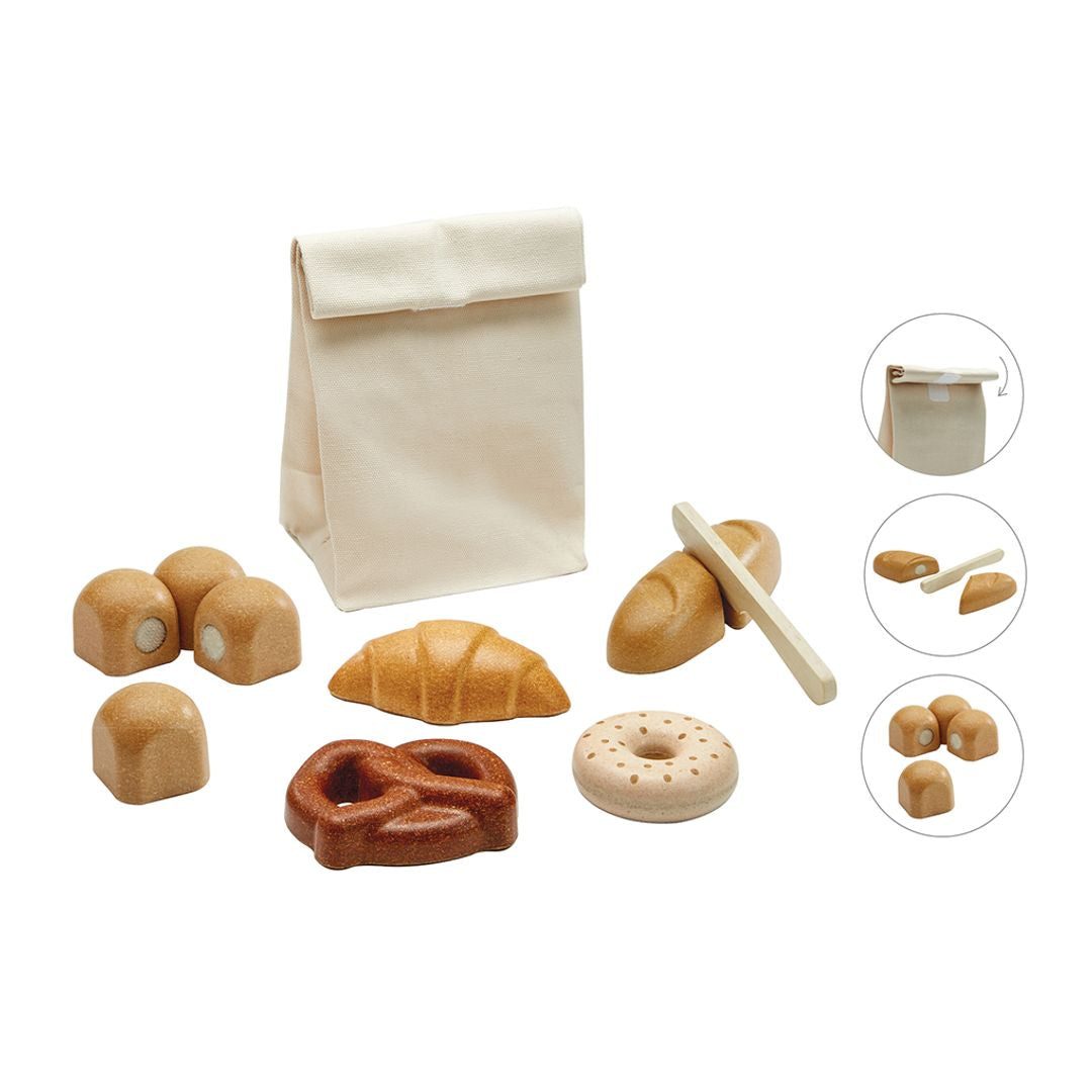 Set of wooden bread toys with a cloth bag on a white background