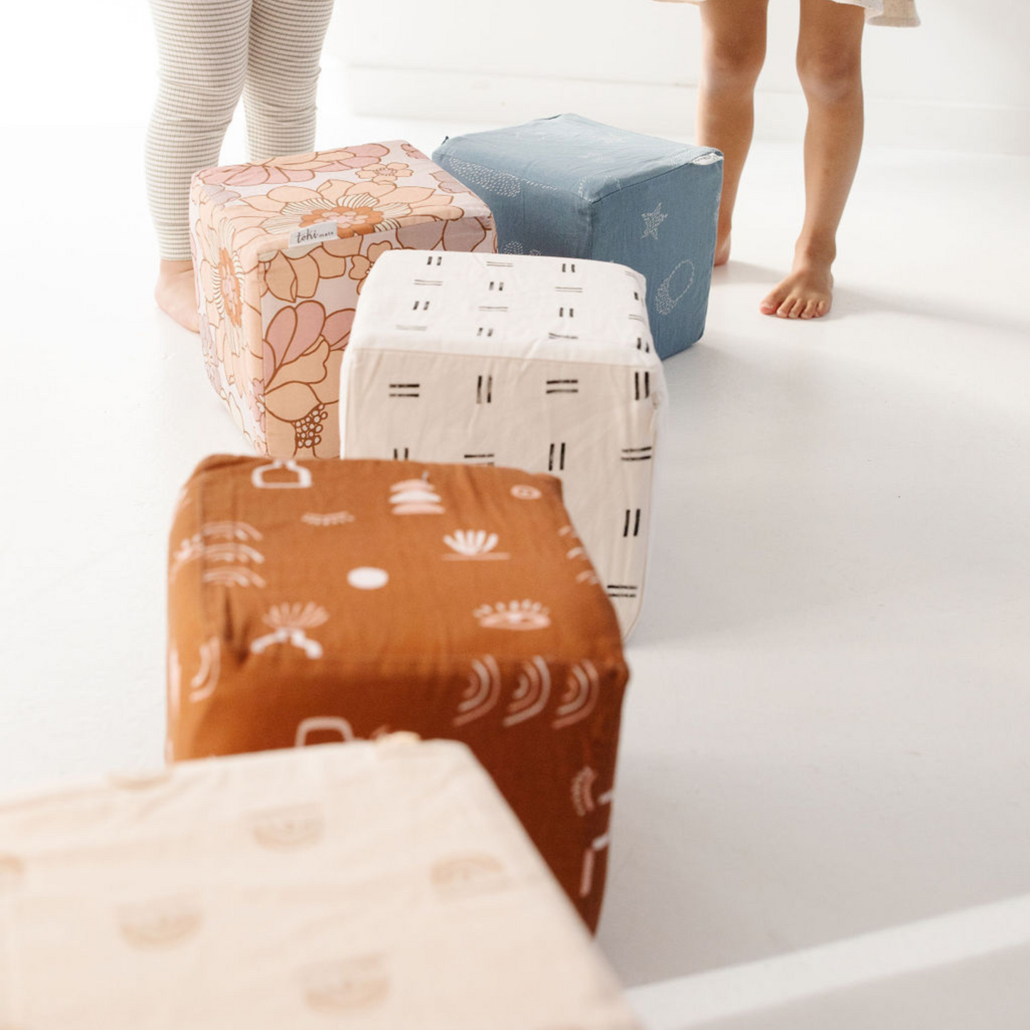 Stack of patterned boxes on a white surface with legs visible at the top.