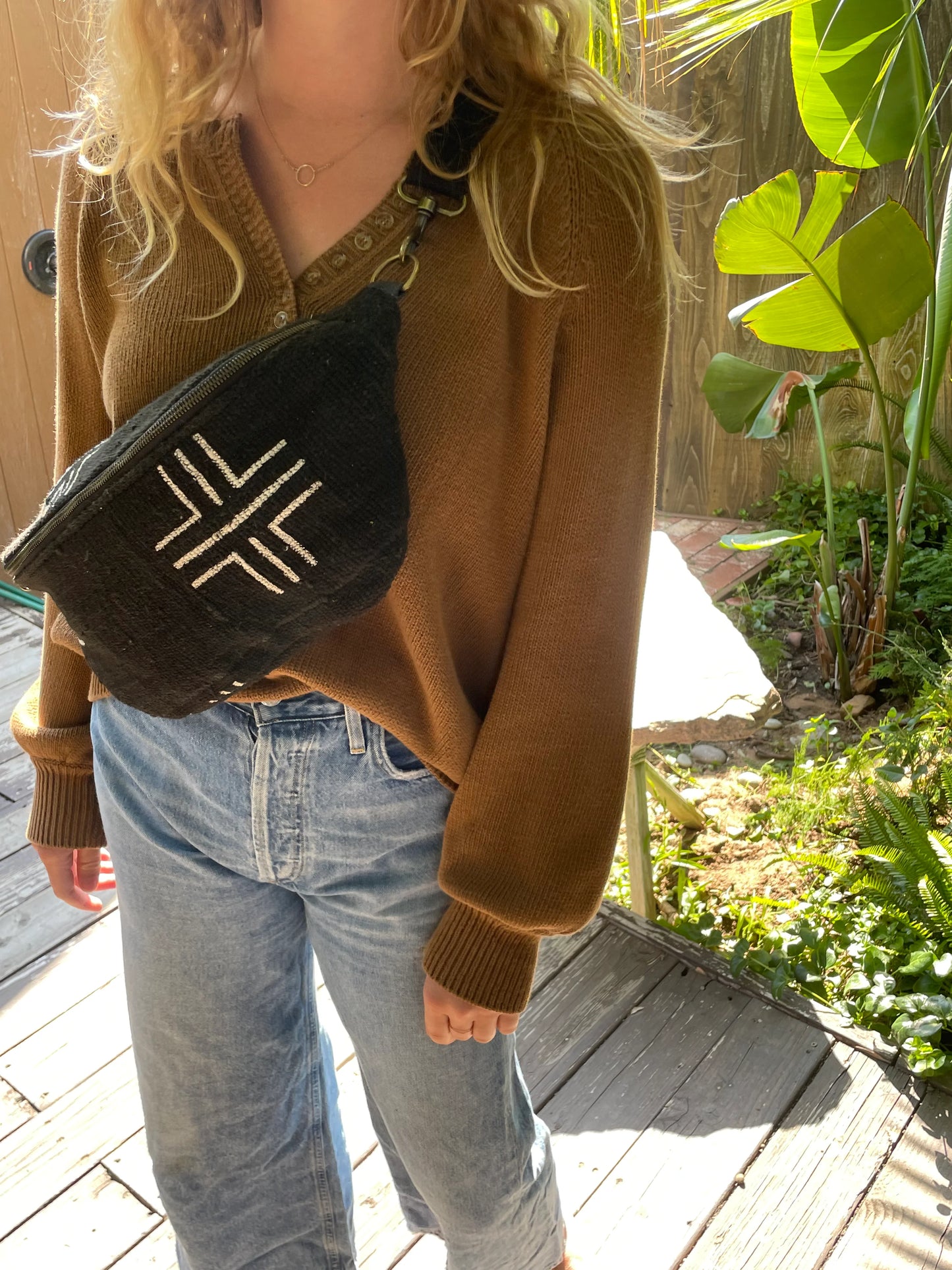 Woman wearing the Jenna Bee black crosses sling bag across her chest.