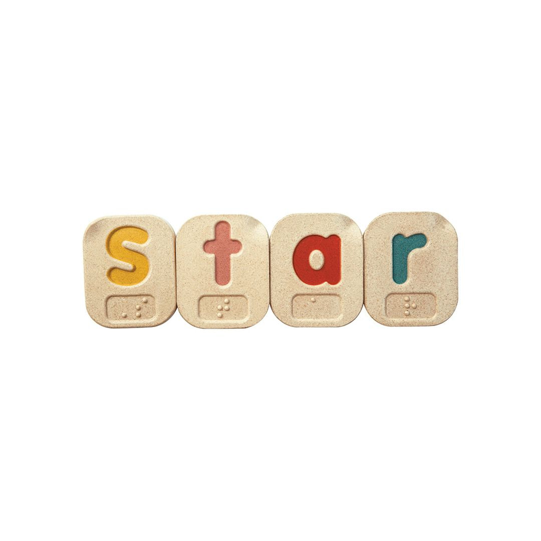 Wooden blocks with colorful letters spelling 'STAR' in braille on a white background