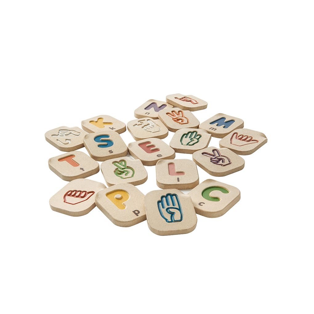 Set of wooden alphabet tiles with colorful letters and symbols on a white background