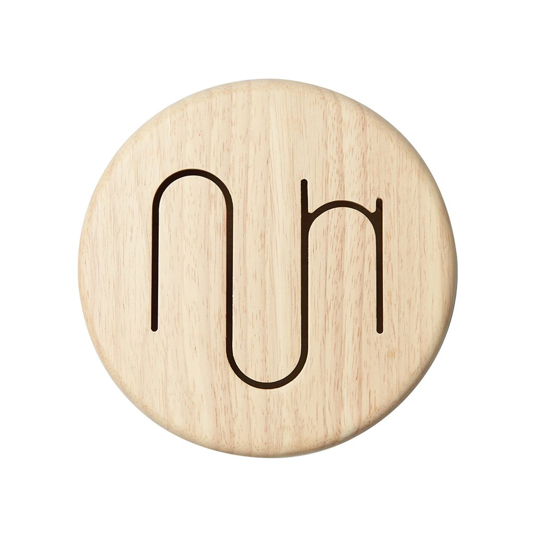 Round wooden coaster with engraved symbols on a white background