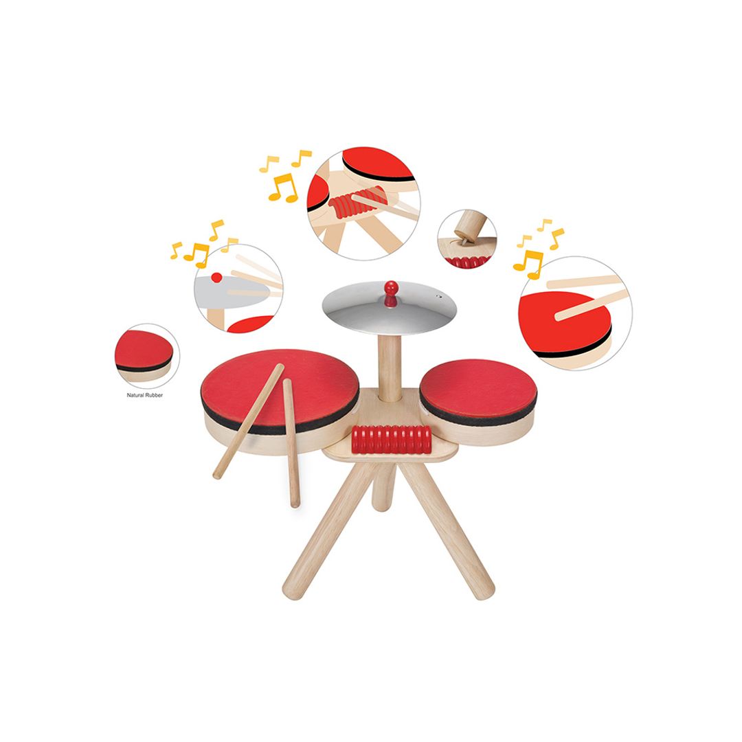 Children's toy drum set with red drums and wooden sticks on a white background