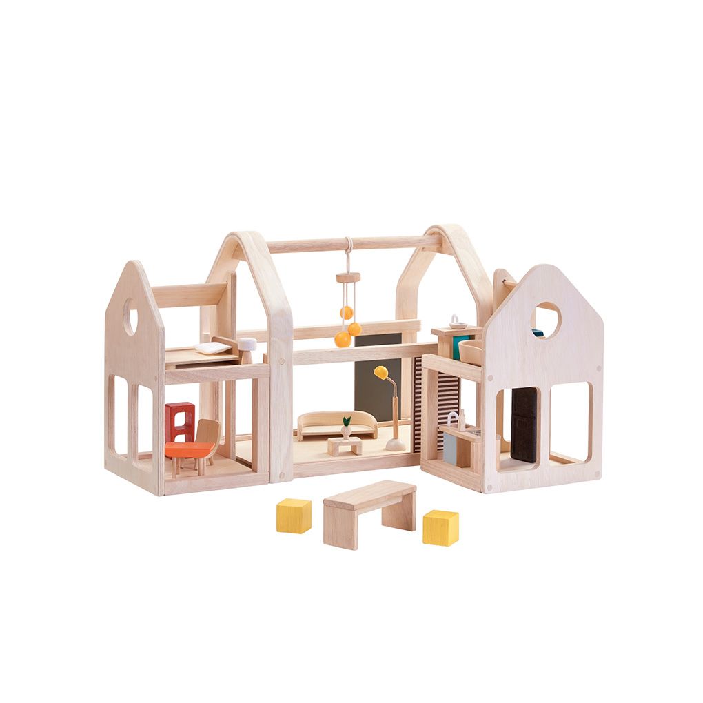 Wooden dollhouse with furniture and accessories on a white background
