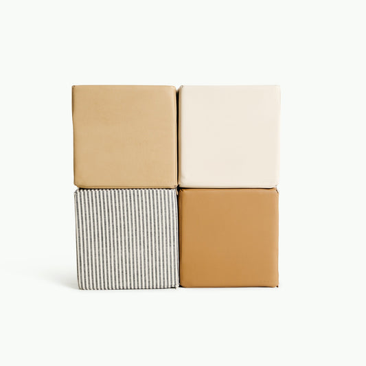 Four square cushions in beige, white, striped gray and brown on a white background