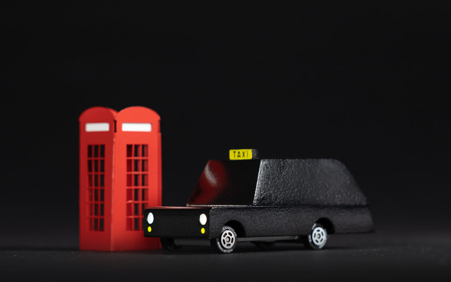 Model taxi and red telephone box on a black background