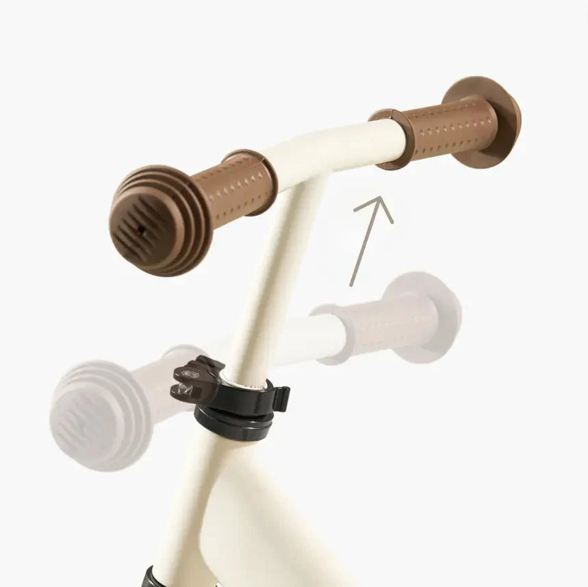 Children's bike handlebar with brown grips on a white background