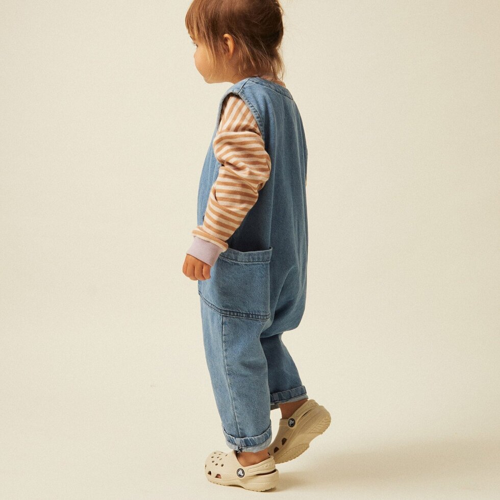 100% Cotton Denim Washed Overalls Sleeveless. Made from mid-weight textured rigid denim with a light wash and Claude and Co stitching.