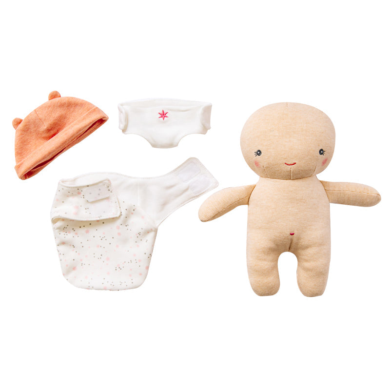 Baby clothing set with a hat, diaper, and soft toy on a white background