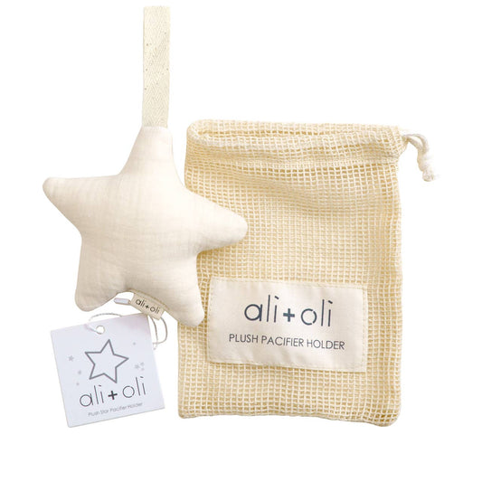 A star-shaped plush pacifier holder in ivory color, made from muslin, with a brand tag attached showing 'ali+oli' and a tag reading 'Plush Pacifier Holder'.