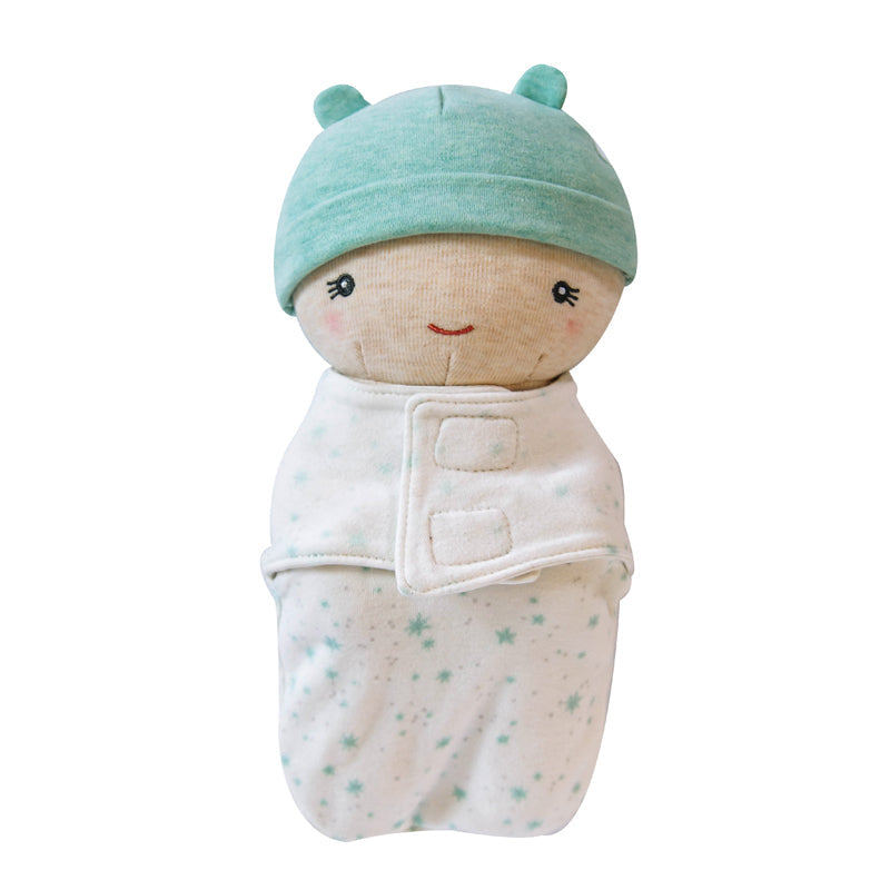 Toy resembling a baby wrapped in a blanket with a green hat on a white background