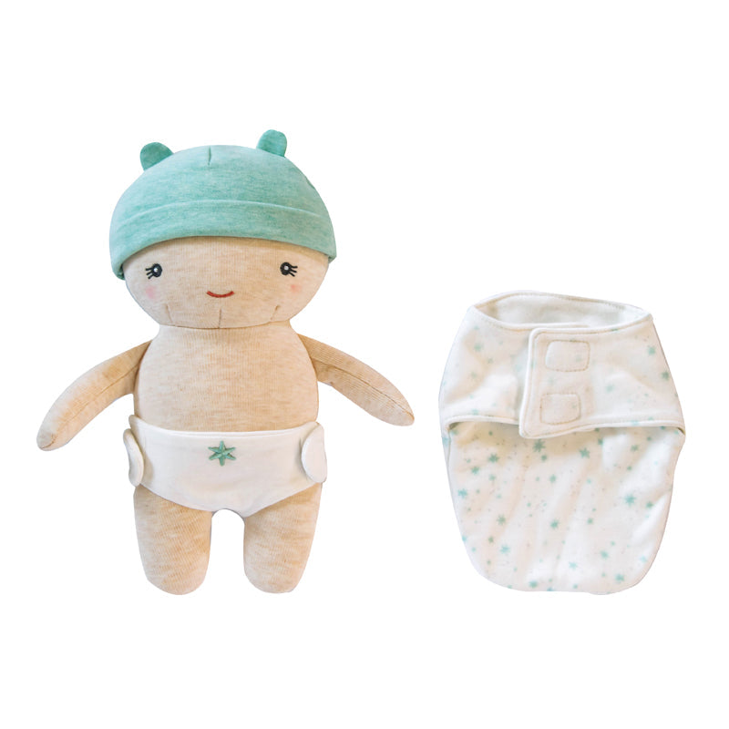Stuffed toy with a green hat and white diaper next to a swaddle blanket on a white background