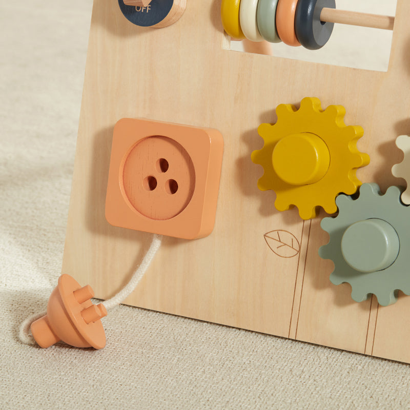 Wooden toy with gears and a button on a beige background