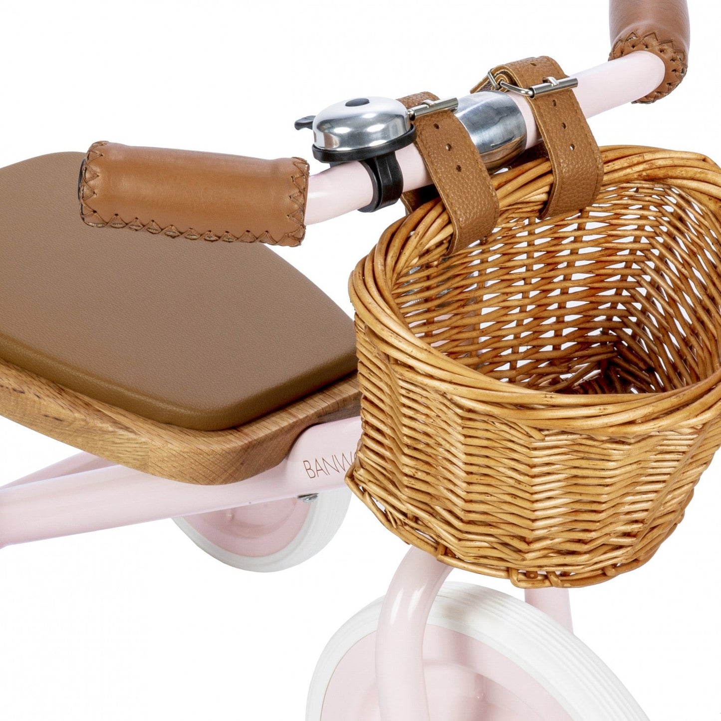Children's tricycle with wicker basket, brown seat, and handlebar bell on a white background