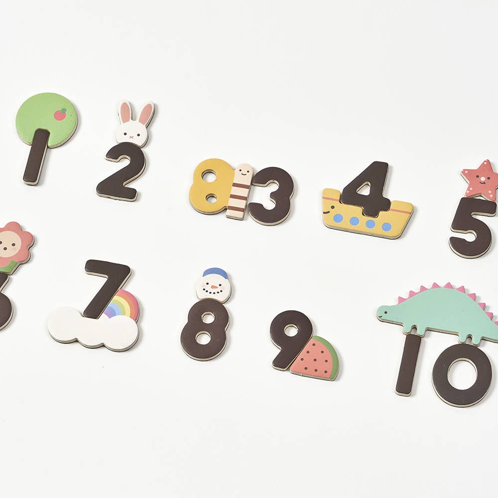Various magnetic pieces including numbers, bunny, boat, star, watermelon, snowman, dinosaur, rainbow cloud, and tree.