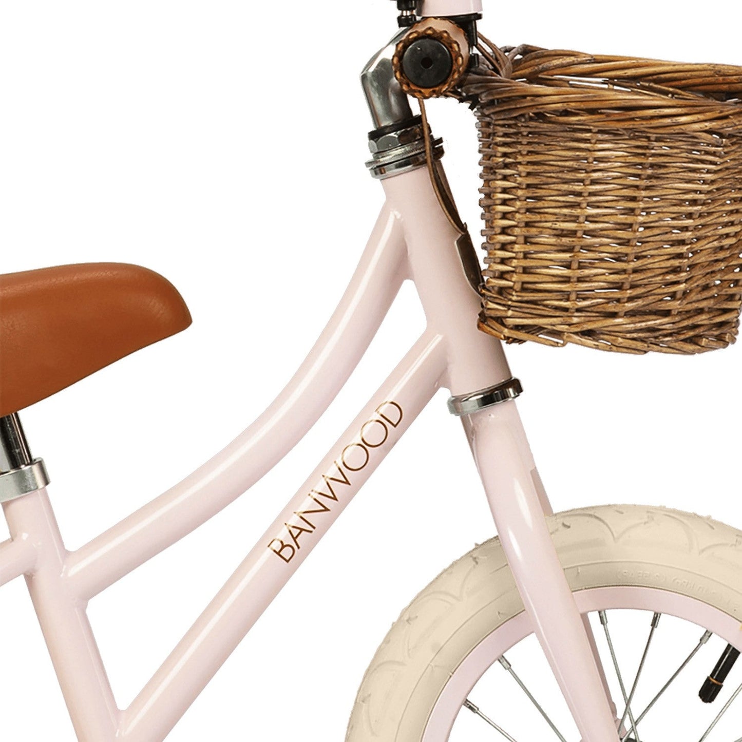 Pink children's bicycle with a wicker basket and brown seat on a white background