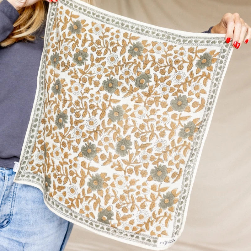 Woman holding a floral patterned fabric in a workshop setting