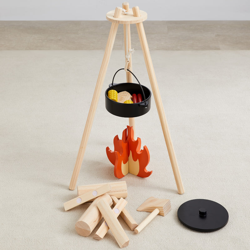 Wooden toy campfire set with a tripod stand, black pot, and wooden logs on a light background