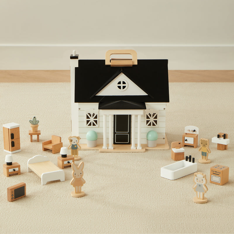 Wooden toy house with various furniture and accessories on a neutral background