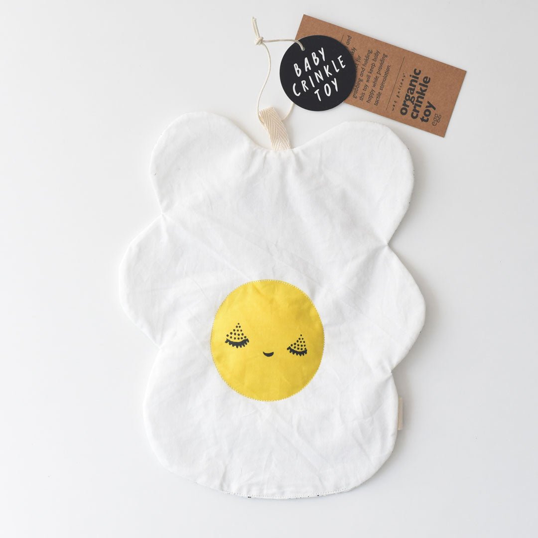 White crinkle toy with a yellow smiley face on a white background