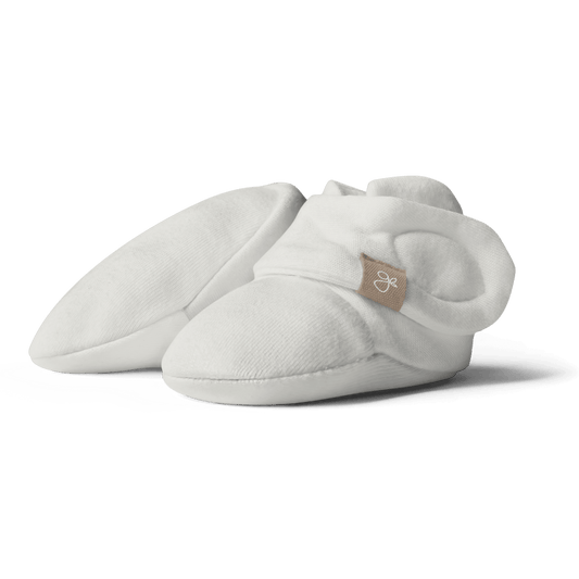 White baby booties with a brand logo on a transparent background