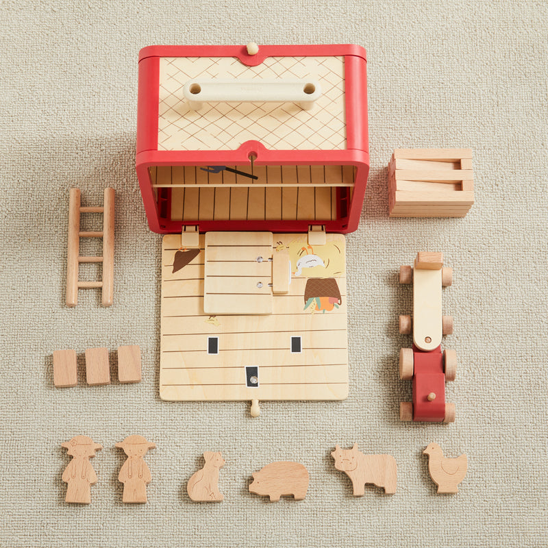 Wooden toy set with a red chest, ladder, blocks, and animal figures on a beige surface.