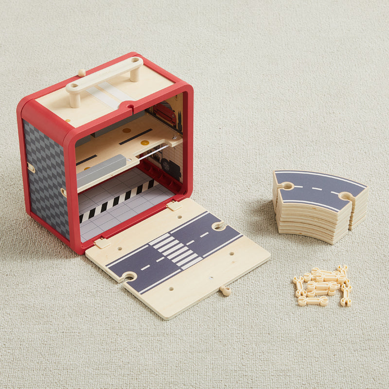Wooden toy race track set with red box on a light gray surface