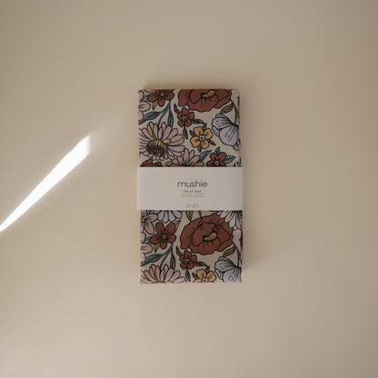 Floral-patterned product packaging with 'mushie' label on a beige background