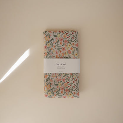 Floral-patterned product with 'mushie' label on a beige background