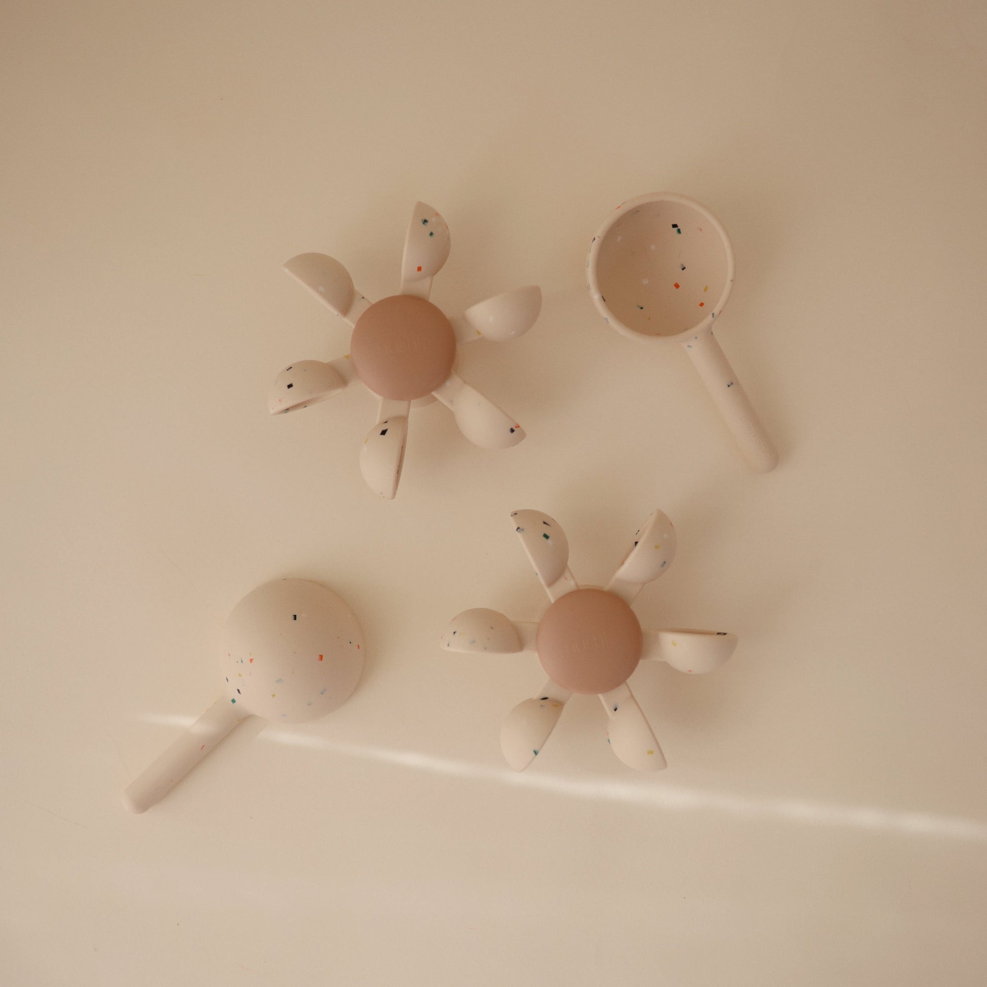 Four bath toys set against a beige backdrop.