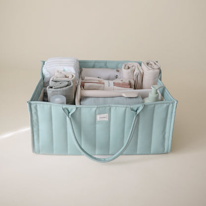 Light blue storage bin with folded clothes on a beige background