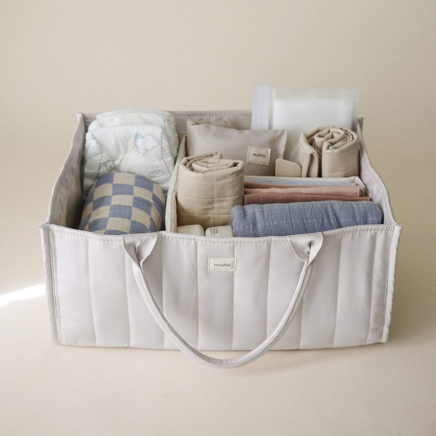 Storage bin with folded clothes on a beige background
