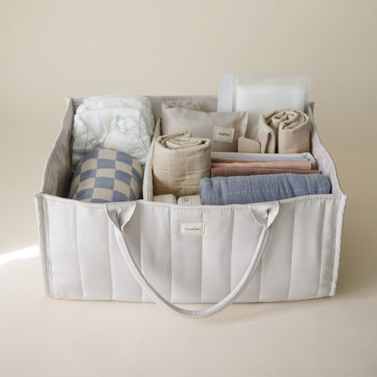 Storage bin with folded clothes on a beige background