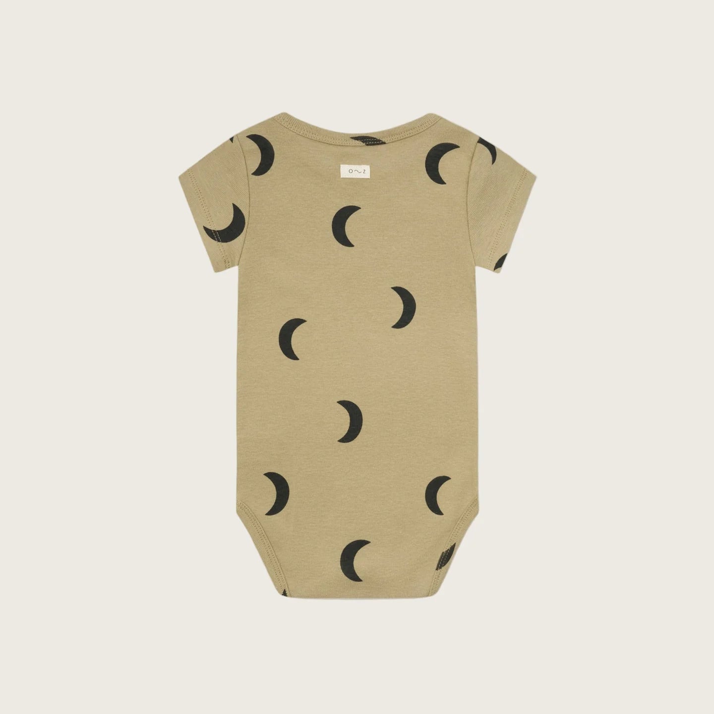 Beige baby onesie with black moon pattern on a white background