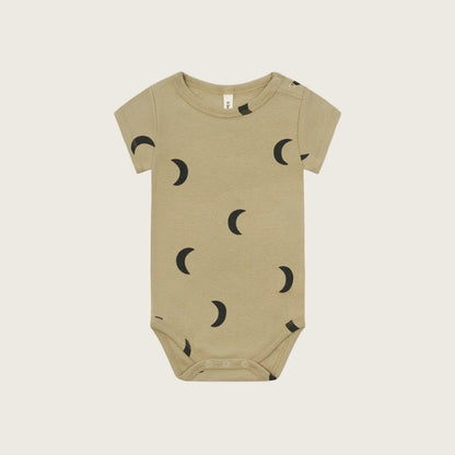 Beige baby onesie with black moon pattern on a white background