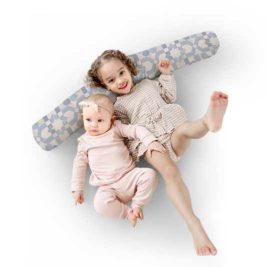 Two children lying on a large blue and gray toy airplane on a white background