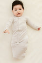Baby in a light gray onesie on a plain background