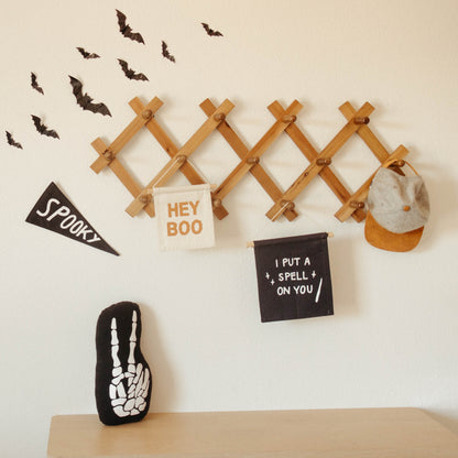 Halloween-themed decorations on a wall with a wooden lattice, bats, and text banners.