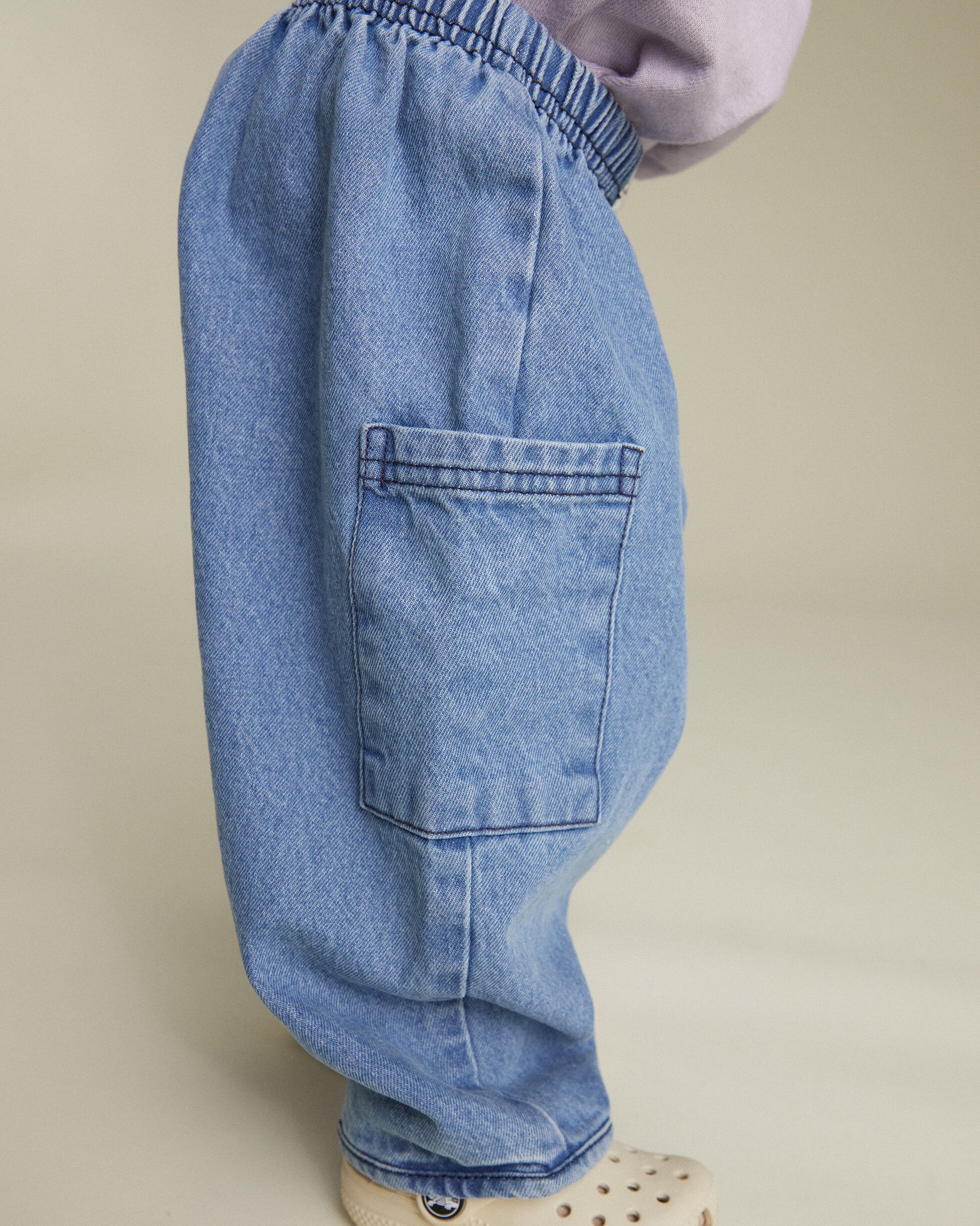 Light blue jeans worn by a person on a beige background